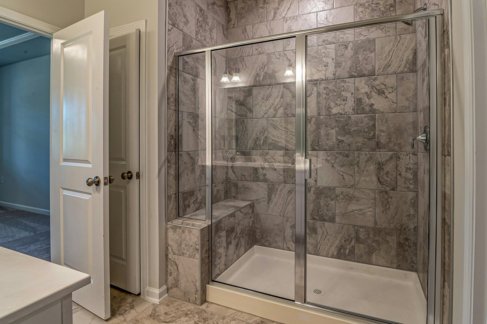 Bathroom remodeling mistakes – luxurious modern bathroom with marble tiled shower built correctly behind the tile